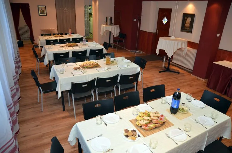 Meghitten megterített asztalok a rendezvényteremben